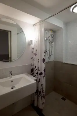 a bathroom with a sink and a shower curtain at Surachet at 257 Boutique House in Phuket Town