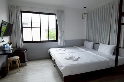 a hotel room with a bed and a window at Surachet at 257 Boutique House in Phuket Town