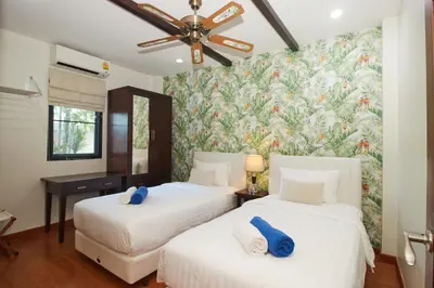 two beds in a room with a floral wallpaper at Baan Ping Tara Private Pool Villa in Ao Nang Beach