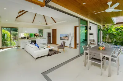a dining room and living room with a table and chairs at Laem Ka Residence by Tropiclook in Rawai Beach