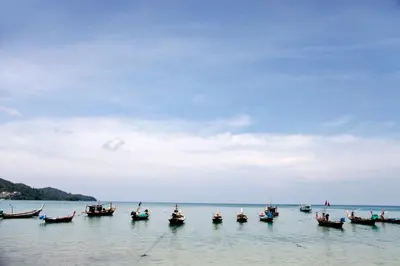 a group of boats sitting in the water at La Ville Phuket Pool Villa in Nai Yang Beach