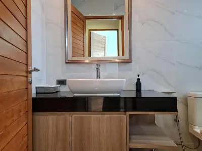 a bathroom with a sink and a mirror at La Ville Phuket Pool Villa in Nai Yang Beach