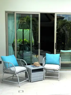 two chairs and a coffee table on a patio at La Ville Phuket Pool Villa in Nai Yang Beach
