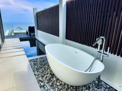 a bath tub in a bathroom with a view of the ocean at Villa Saan - SHA Extra Plus in Kamala Beach
