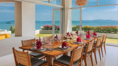 a dining room with a long table and chairs at Villa Leelawadee in Por Bay