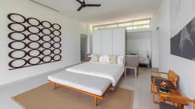 a white bedroom with a bed and a table at Villa Leelawadee in Por Bay