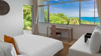 a bedroom with a bed and a desk and a window at Villa Leelawadee in Por Bay