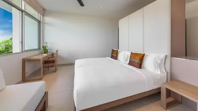 a white bedroom with a large bed and a window at Villa Leelawadee in Por Bay