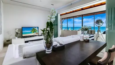 a living room with a white couch and a table at Villa Paradiso in Nai Thon Beach