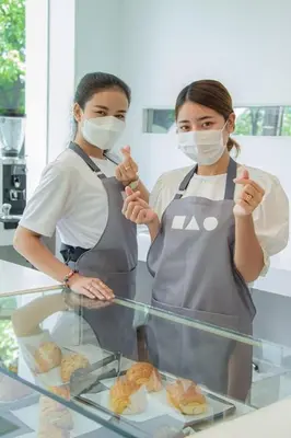two women standing in a kitchen with masks on their faces at Hao Hostel Phuket in Phuket Town