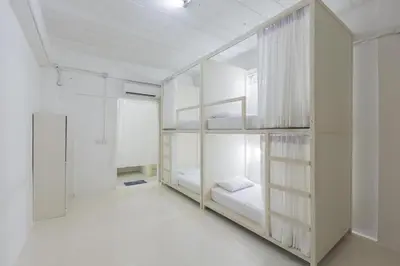 a white room with a bunk bed in it at Hao Hostel Phuket in Phuket Town