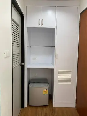 a small closet with white cabinets and a trash can at Sleep at Phuket SHA Plus in Phuket Town
