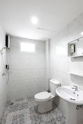 a white bathroom with a toilet and a sink at Sleep at Phuket SHA Plus in Phuket Town
