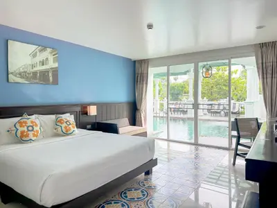 a bedroom with a large bed and a balcony at Grand Supicha City Hotel in Phuket Town