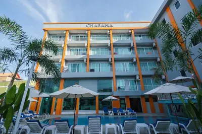 a hotel with chairs and umbrellas next to a pool at Chabana Kamala Hotel in Kamala Beach