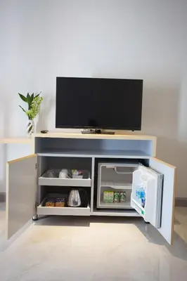 a small refrigerator with a tv on top of it at Chabana Kamala Hotel in Kamala Beach