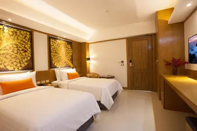 a hotel room with two beds and a television at Chabana Kamala Hotel in Kamala Beach