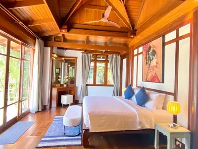 a bedroom with a large bed in a room with windows at Luxury Seaview Villa Surin Beach Phuket in Surin Beach