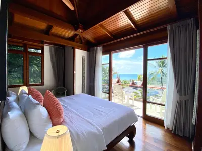 a bedroom with a bed with a view of the ocean at Luxury Seaview Villa Surin Beach Phuket in Surin Beach