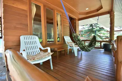 a porch with two white chairs and a hammock at Namtok Bungalows in Ko Yao Noi