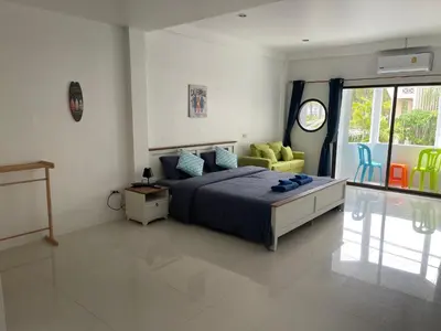 a bedroom with a bed and a yellow chair at Skipper's Karon in Karon Beach