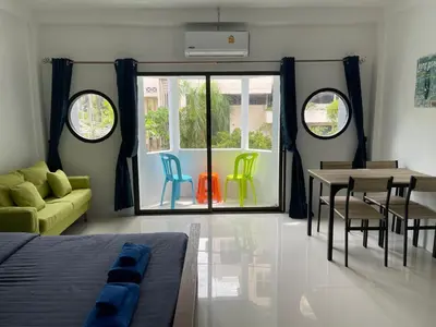 a room with a bed and a table and chairs at Skipper's Karon in Karon Beach