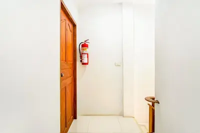 an open door with a fire extinguisher on the wall at Skipper's Karon in Karon Beach