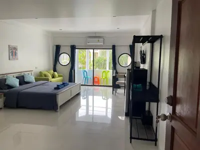 a bedroom with a bed and a living room at Skipper's Karon in Karon Beach