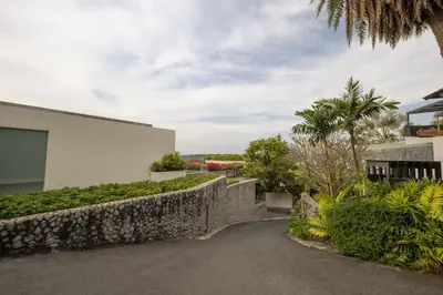 a driveway leading to a house with a stone wall at Bluesiam Villas - SHA Certified in Surin Beach