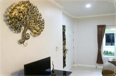a chandelier hanging from a wall in a living room at Vacation Garden Villa in Thalang