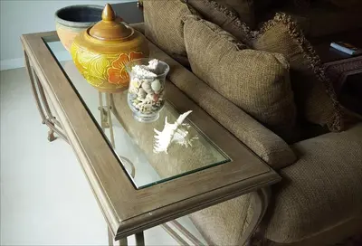 a glass table with a vase on top of a couch at Vacation Garden Villa in Thalang