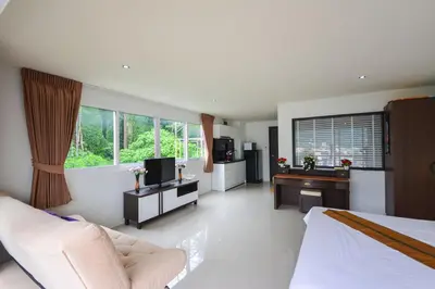 a bedroom with a bed and a desk and a television at BeststayinPhuket Mountain Poolviews in Patong Beach