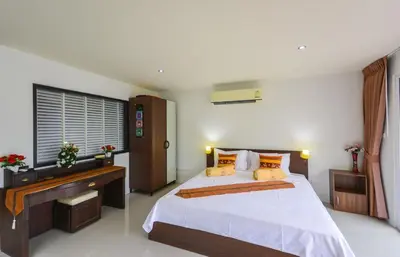 a bedroom with a large bed and a desk at BeststayinPhuket Mountain Poolviews in Patong Beach