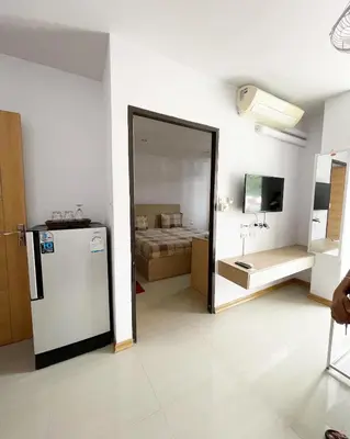 a room with a refrigerator and a bedroom with a bed at The C Park in Patong Beach