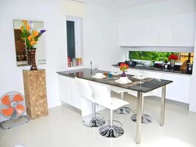 a kitchen with a table and two white chairs at Skylight 2 bedrooms Villa in Kamala in Kamala Beach