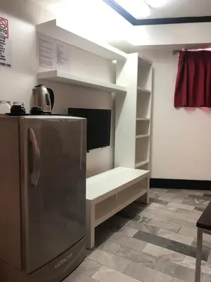 a kitchen with a refrigerator and a shelf at Patong Holiday Dream Hotel in Patong Beach