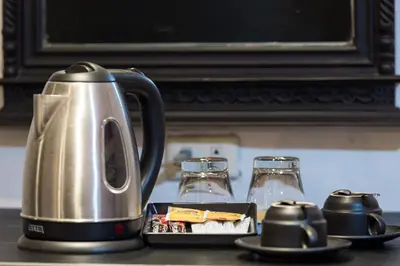 a tea kettle and a plate of food on a counter at Patong Holiday Dream Hotel in Patong Beach