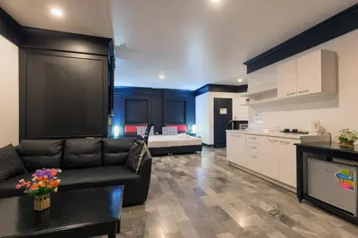 a living room with a couch and a kitchen at Patong Holiday Dream Hotel in Patong Beach