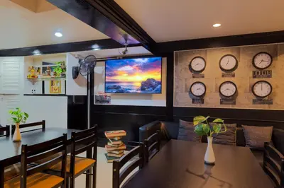a dining room with a table and clocks on the wall at Patong Holiday Dream Hotel in Patong Beach