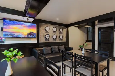 a dining room with a table and chairs and a tv at Patong Holiday Dream Hotel in Patong Beach