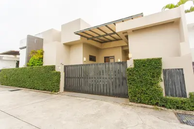 a house with a black gate in front of a driveway at Honeymooner Pool Villa@Seastone in Bang Tao Beach