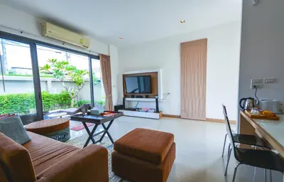 a living room with a couch and a table at Honeymooner Pool Villa@Seastone in Bang Tao Beach