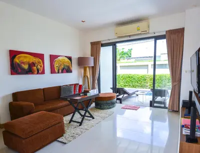 a living room with a couch and a table at Honeymooner Pool Villa@Seastone in Bang Tao Beach