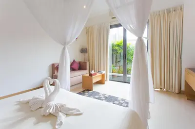 a bedroom with a bed with white curtains and a room at Honeymooner Pool Villa@Seastone in Bang Tao Beach