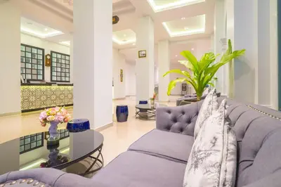 a living room with a purple couch and a glass table at Vapa Hotel - SHA Extra Plus in Phuket Town