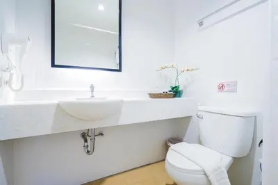 a white bathroom with a sink and a toilet at Vapa Hotel - SHA Extra Plus in Phuket Town