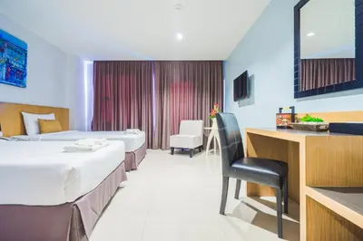 a hotel room with two beds and a desk at Vapa Hotel - SHA Extra Plus in Phuket Town
