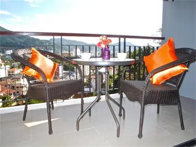 a table and chairs on a balcony with a view at Bliss Patong 2 bedrooms Apartment in Patong Beach