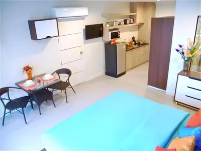 a living room with a table and a kitchen at Bliss Patong 2 bedrooms Apartment in Patong Beach