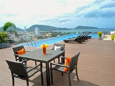 a table and chairs on a balcony with a pool at Bliss Patong 2 bedrooms Apartment in Patong Beach